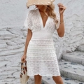 Detail of white crochet deep V-neck beach dress showing hollow knit texture and wavy hemline - S / Tops / White