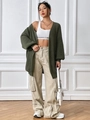 Detail of dark green chunky knit cardigan paired with white crop top and khaki cargo pants - S / Green