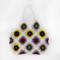 Detail einer handgehäkelten Tragetasche mit bunten Granny-Square-Blumenmustern auf Weiß - Weiß