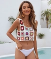 Dettaglio di motivi floreali colorati all'uncinetto su un crop top estivo bianco - Taglia unica / Albicocca