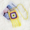 Detail der handgehäkelten Umhängetasche mit bunten Boho-Mustern und langen Fransenquasten - Gelb