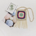 Macro detail of handmade crochet bohemian crossbody bag with colorful squares and fringe - Apricot
