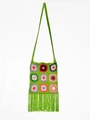 Detailed macro view of handmade granny square crochet shoulder bag with colorful tassels - Green