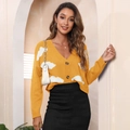 Close-up of yellow knit cardigan with cloud patterns and brown buttons for casual style - Yellow
