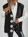 Detail of knit vest featuring 3D white crochet flowers and elegant pearl buttons on black fabric - One Size / Black