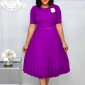 Close-up of pleated purple dress with belt buckle and white flower brooch detail - Violet