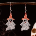 Close-up of glittery ghost earrings with orange wizard hats hanging on a rustic branch - Orange Wizard Hat Ghost Earrings
