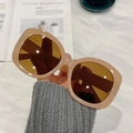 Chic beige square oversized sunglasses with brown lenses held by hand against a marble desk - Fruit Tea Frame Tea Lenses