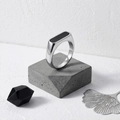 Macro shot of silver stainless steel ring with black rectangular inlay on stone pedestal - Steel-black / Size 5
