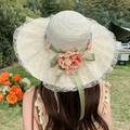 Beige wide-brim straw sun hat with white lace, green ribbon, and orange floral decor - Flower Green Ribbon - Creamy White