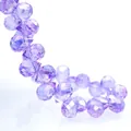 Macro detail of faceted purple K9 crystal glass beads with light-reflecting rhombus surfaces - Natural Crystal Purple AB / 6mm (approximately 87 Beads Per Strip)