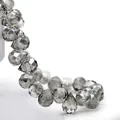 Macro shot of smoky grey faceted teardrop crystal beads with polished light-reflecting surfaces - Smoke Gray / 6mm (approximately 87 Beads Per Strip)