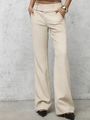 Detailed close-up of high-waisted beige trousers featuring side buckles and side pockets - Apricot