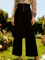 Detail der schwarzen weiten Hose mit hoher Taille und Zierknöpfen in einer Gartenumgebung - S / Schwarz