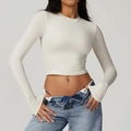 Detail of white tight yoga top featuring long sleeves with functional thumb holes - Cream Apricot