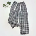 Detail of black and white checkered lounge pants with elastic waist and ribbon drawstring - Black Plaid