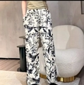 Detail of floral print wide-leg pants featuring side pockets and elegant black leaf patterns - One Size / Botanical Print