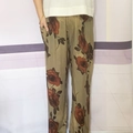 Detail showing the side pocket and vintage red rose floral print on green trousers - One Size / Vintage Rose Print