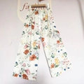 Detail of floral wide-leg pants featuring elastic waistband and white decorative drawstring - Poppy