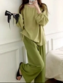Detalle de un conjunto de pijama de algodón fino y suelto con manga larga en verde claro y oscuro - Verde fruta