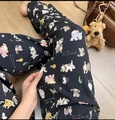 Detail view of cotton pajama pants with cute cartoon dog patterns on black fabric - Dog Party