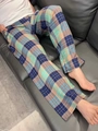 Dettaglio del tessuto dei pantaloni casual a quadri su un divano in pelle nera - Taglia unica / Plaid Blu e Giallo