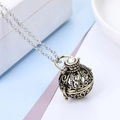 Macro shot of vintage hollow vine pattern on a bronze orb pendant with crystal stone - Hollow Sphere Locket (Includes 5 Cotton Balls 1 Lava Stone) / Antique Bronze