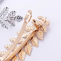 Detailansicht der goldenen und silbernen Haarspangen in Blattform mit feiner Textur - Gold