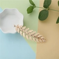 Detailed view of a gold leaf hair clip with a white pearl on a soft pastel background - FJ005 Pearl Gold Hair Clip