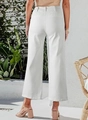 Back view of high waisted wide leg white denim trousers in a sunny summer outdoor setting - S / White