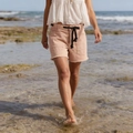 Outdoor shot of pink distressed denim shorts with rope drawstring and frayed hemline - Orange