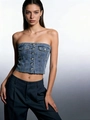 Détail d'un bustier en jean bleu avec boutons frontaux, poches à rabat et ourlet cru - S / Bleu clair