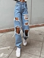 Macro shot of distressed knee details on light blue high-waisted wide-leg denim jeans - Blue