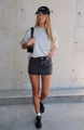 Vista street style di una minigonna di jeans nera slavata attillata con una t-shirt grigia - S / Nero