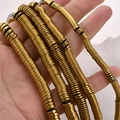 Nahaufnahme von goldenen Hämatit-Distanzscheiben für DIY-Schmuck in der Hand gehalten - 6*1mm/Ca. 330 Stück / Dunkelgold