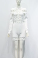 Detail van witte korte jumpsuit met lange mouwen, geometrisch kant en parelknoppen - XS / Wit