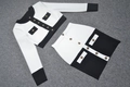Detail view of contrast knit jacket and mini skirt with elegant gold relief buttons - XS / White + Black