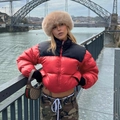 Detail der rot-schwarzen Pufferjacke mit dicker brauner Webpelzmütze in Outdoor-Umgebung - S / Rot