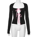 Detail of black long sleeve top showing pink satin bow ties and square neckline cut-outs - L / Black