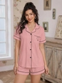 Detail of pink pajama set featuring black contrast piping and heart embroidery on pocket - S / Pink
