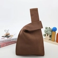 Detailed view of brown knitted knot bag with textured weave and soft handle material - Coffee