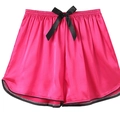 Detail view of rose pink satin lounge shorts with black bow tie and curved hem design - Rose Red