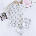 Vue détaillée du pyjama en coton blanc pour femme avec motif cœur noir sur literie rayée - Blanc avec Coeur Noir