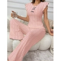 Detailed view of pink knitted loungewear set featuring lace hollow texture and bow accent - Pink