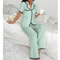 Detail of light green pajama set with lapel collar and decorative black wavy lace edges - Green