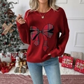 Gros plan du pull de Noël rouge pour femmes avec nœud à carreaux et maille détaillée - S / Rouge