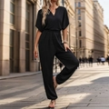 Elegante zwarte jumpsuit met diepe V-hals, tailleband en wijde pijpen in een urban stijl - S / Zwart