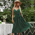 Dark green polka dot summer dress with pleated hem and spaghetti straps in a garden - M / Green