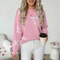 Maglione in maglia rosa a girocollo con motivi jacquard a fiocco bianco e polsini a coste - S / Rosa