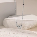Collana in acciaio argento con ciondolo a fiocco traforato e perline metalliche decorative - Collana Con Perline Rotonde Con Fiocco / Colore acciaio